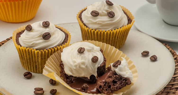 Imagem ilustrativa de cupcakes de café com chantilly (cupcakes de massa marrom com chantilly cremoso por cima e com grãos de café)